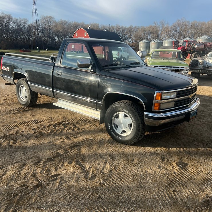 Lot 8. 1990 Chevy 1/2 ton 4wd pickup, black, reg cab long box, automatic trans., gas, new tires, Note: Endgate stored in shop and is included in sale. 
VIN 1GCDK14K4LE223081