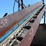 approx-250'-barn-sweep-conveyor-w/-patz-style-chain-w/-40'-incline-section-w/heavy-duty-hydraulic-drive-w/-the-rest-of-the-chain-riding-on-concrete-base-w/-idler-rolls-image-3