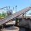 approx-250'-barn-sweep-conveyor-w/-patz-style-chain-w/-40'-incline-section-w/heavy-duty-hydraulic-drive-w/-the-rest-of-the-chain-riding-on-concrete-base-w/-idler-rolls-image-1