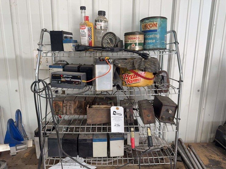 assorted-garage-shelf-contents-including-automotive-fluids,-batteries,-charger,-and-accessories-image-1