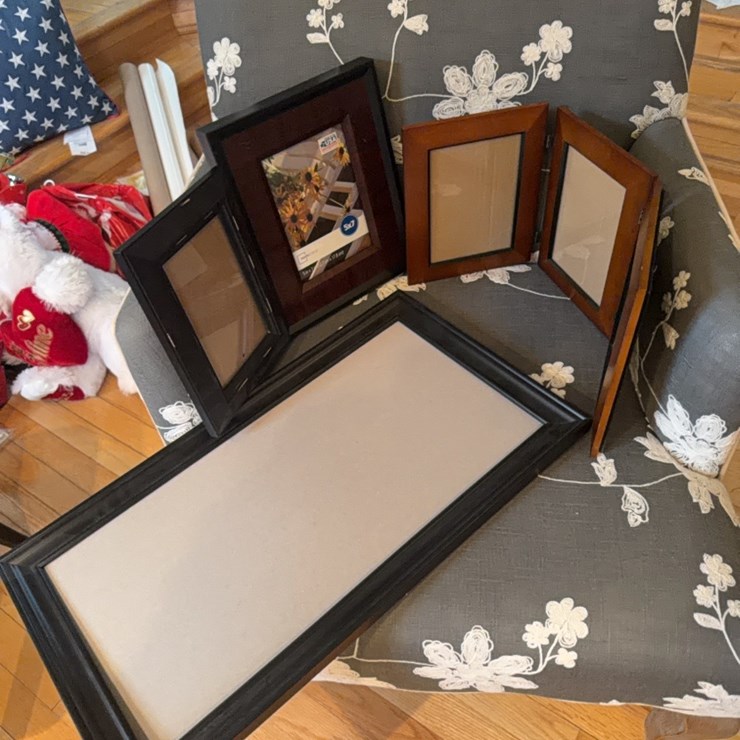 Various unused picture frames and tablecloth. also magazine rack.