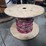 large-wooden-spool-with-cantinos-length-of-mulit-color-stranded-electrical-wire-with-red,-white,-black,-and-green-strands-image-1